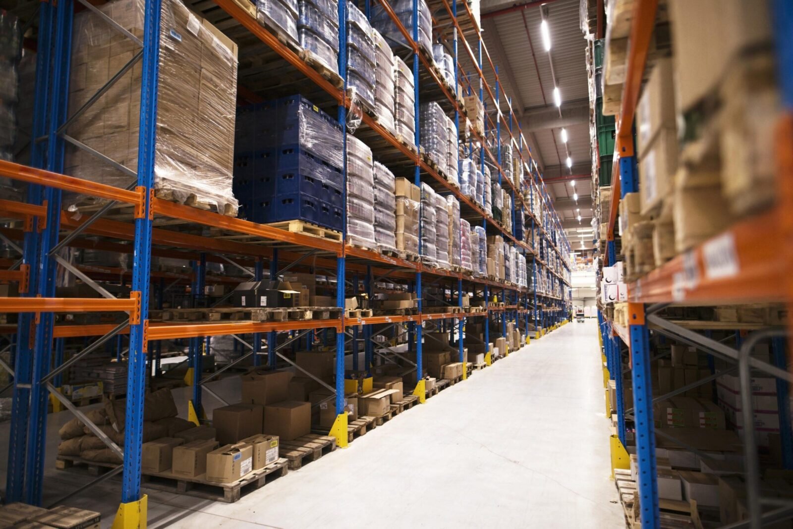 Interior large distribution warehouse with shelves stacked with palettes goods ready market min scaled